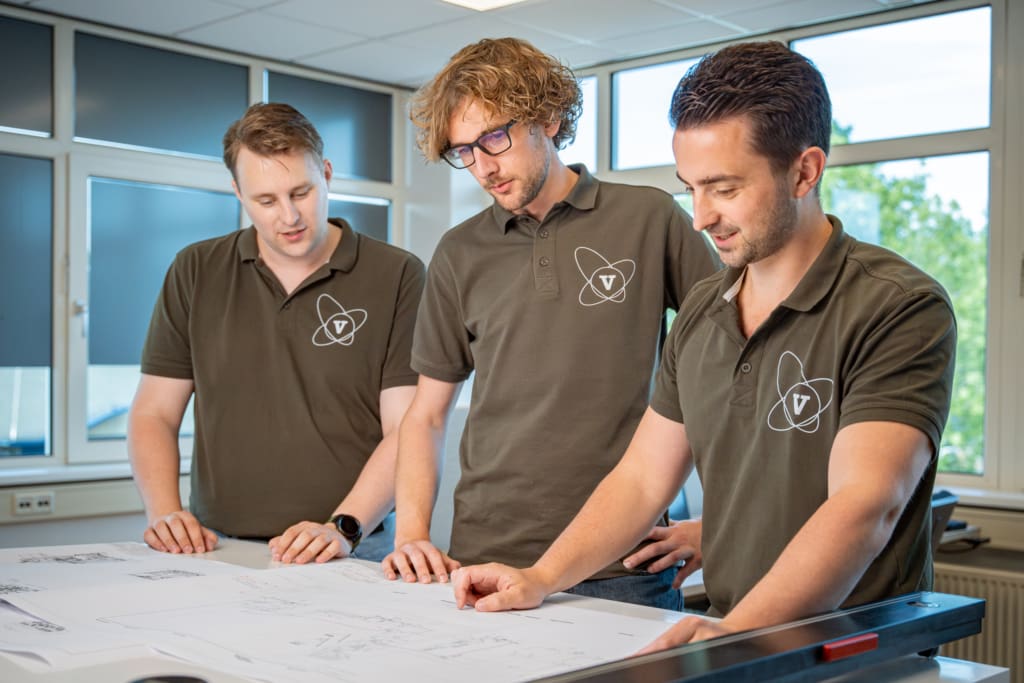 Three Vomatec team members reviewing machine designs during project meeting