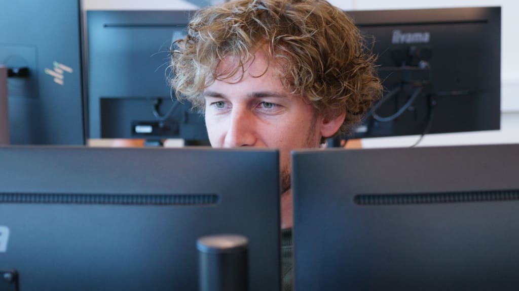 Vomatec engineer developing a custom confectionery production line behind dual screens